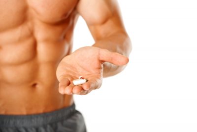 fit guy holding pills