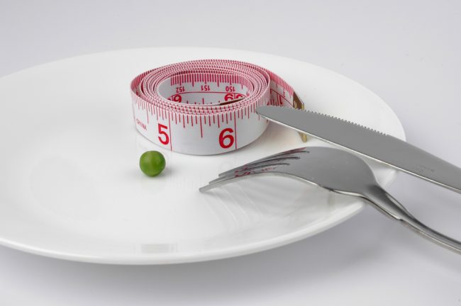 a pea and a tape measure on a plate